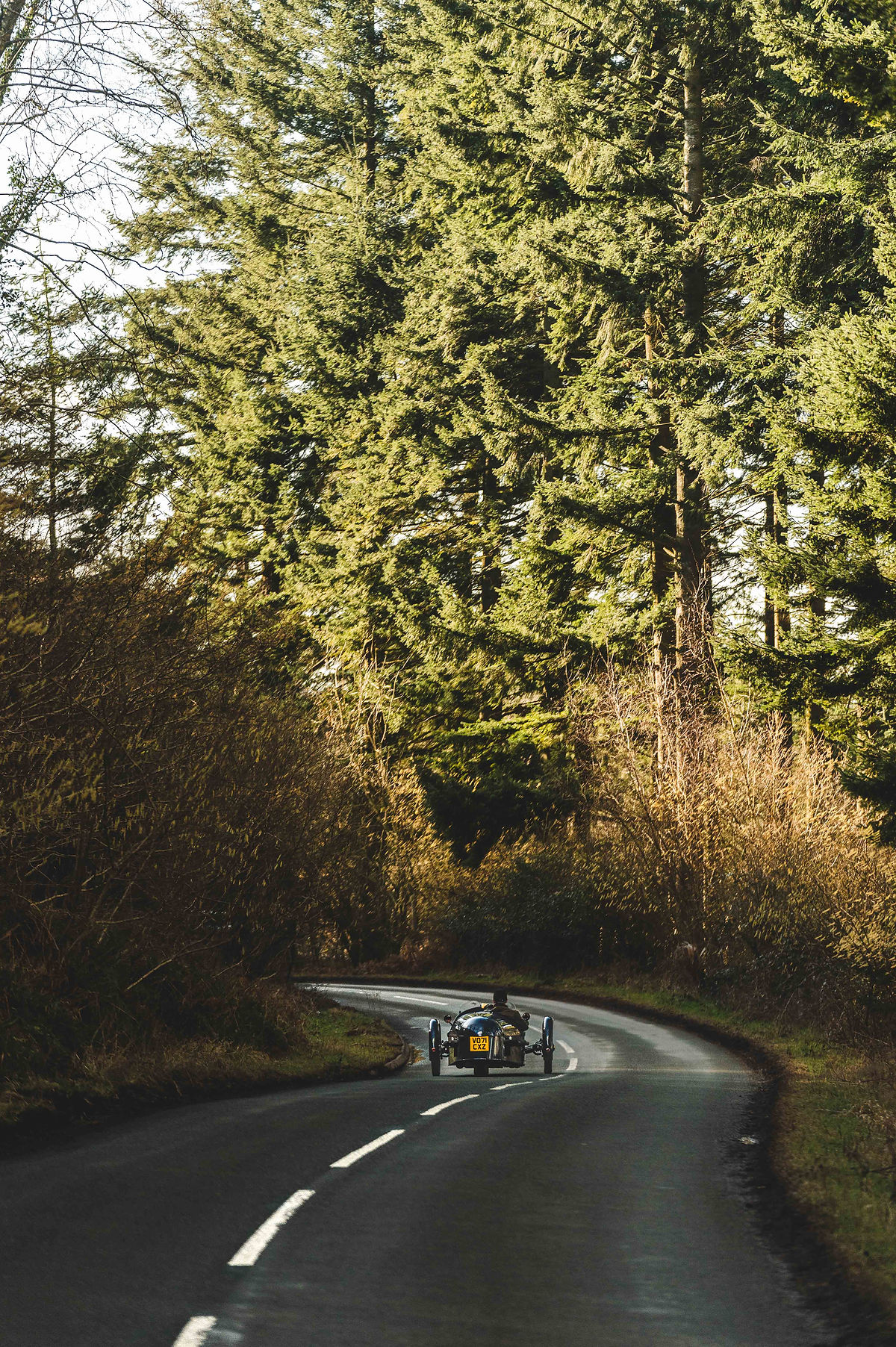 An open top Pembleton sports car on a road trip through lovely landscapes