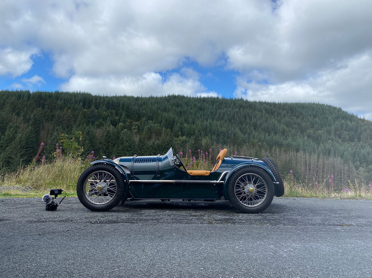 An open top Pembleton sports car on a road trip through lovely landscapes