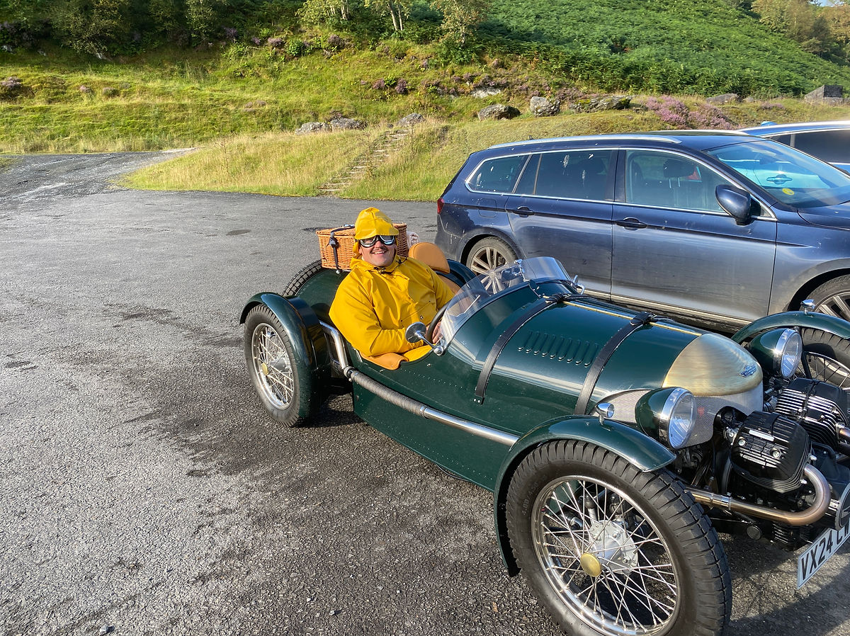 An open top Pembleton sports car on a road trip through lovely landscapes